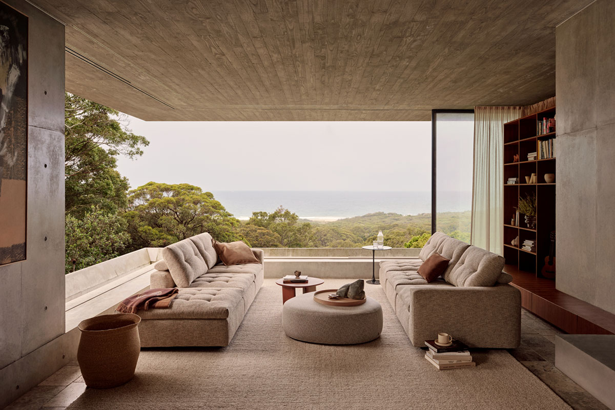 Coastal open plan room with indoor outdoor flow facing the ocean, styled with a modern large modular sofa.