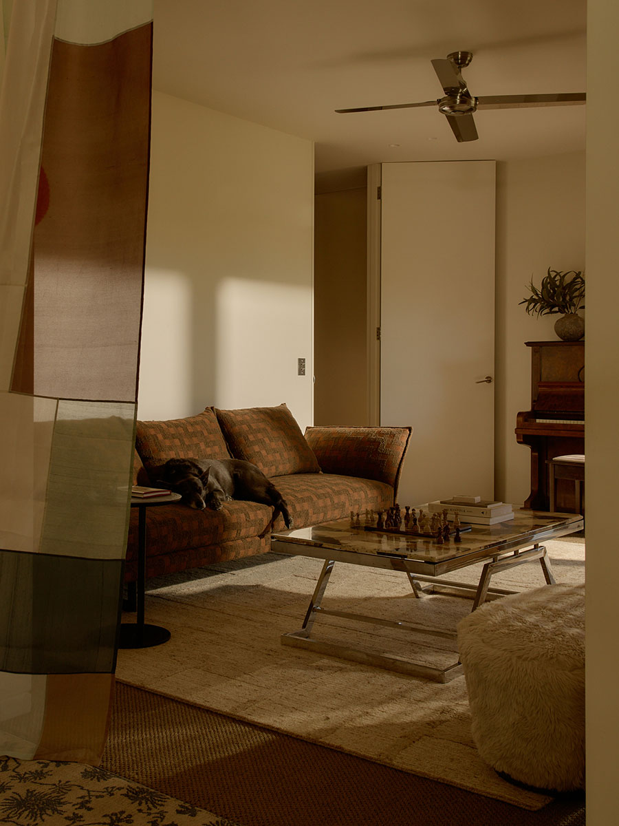 Small space living room with vintage-style décor including a checkered sofa fabric in a warm rust tone and soft rug.