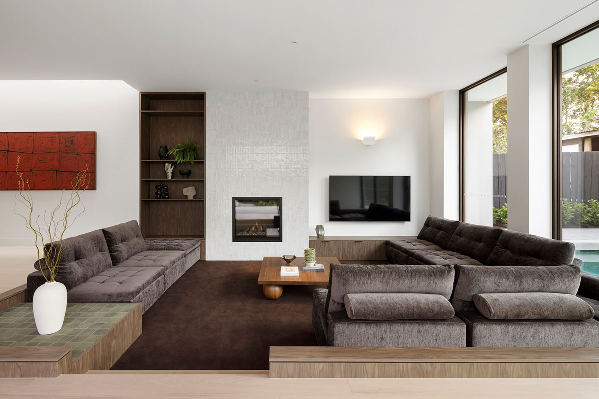 Modular sofa with deep seats and tufted styling in a mocha mousse brown velvet fabric, positioned in a contemporary sunken lounge.