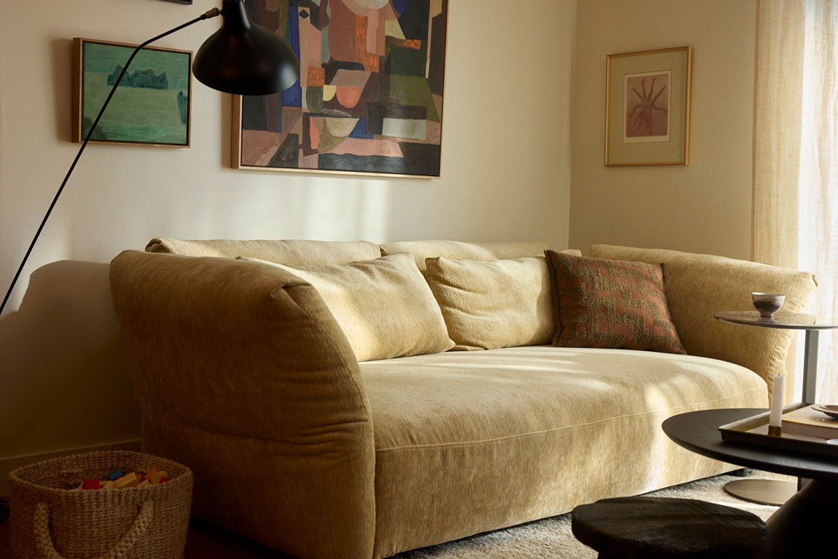 A modular sofa in a small living room, styled with a floor lamp and gallery wall art.