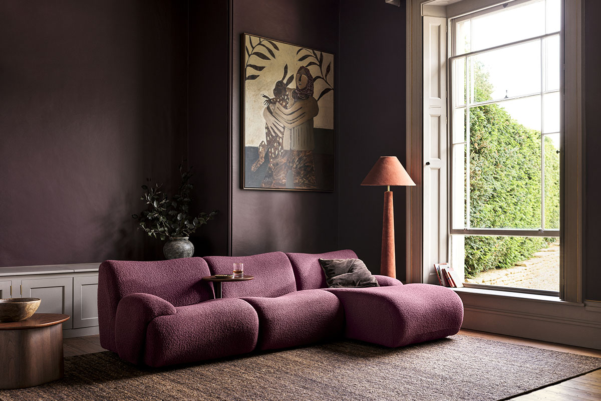 Curved modular 1977 Sofa in pinot noir bouclé fabric. Styled in colour drenched burgundy living room. 