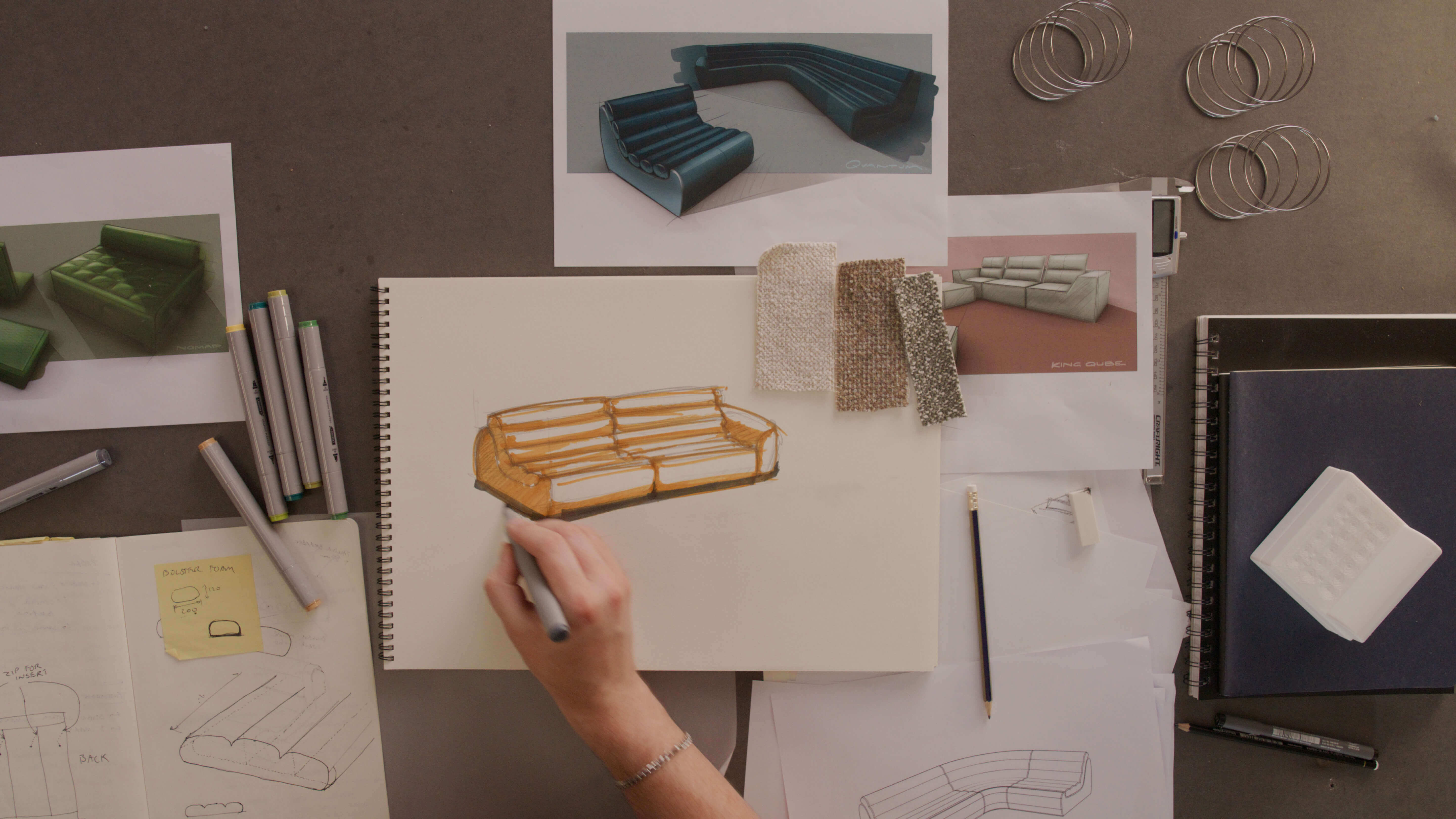 Workshop desk with sketches and prototypes of designs (above).