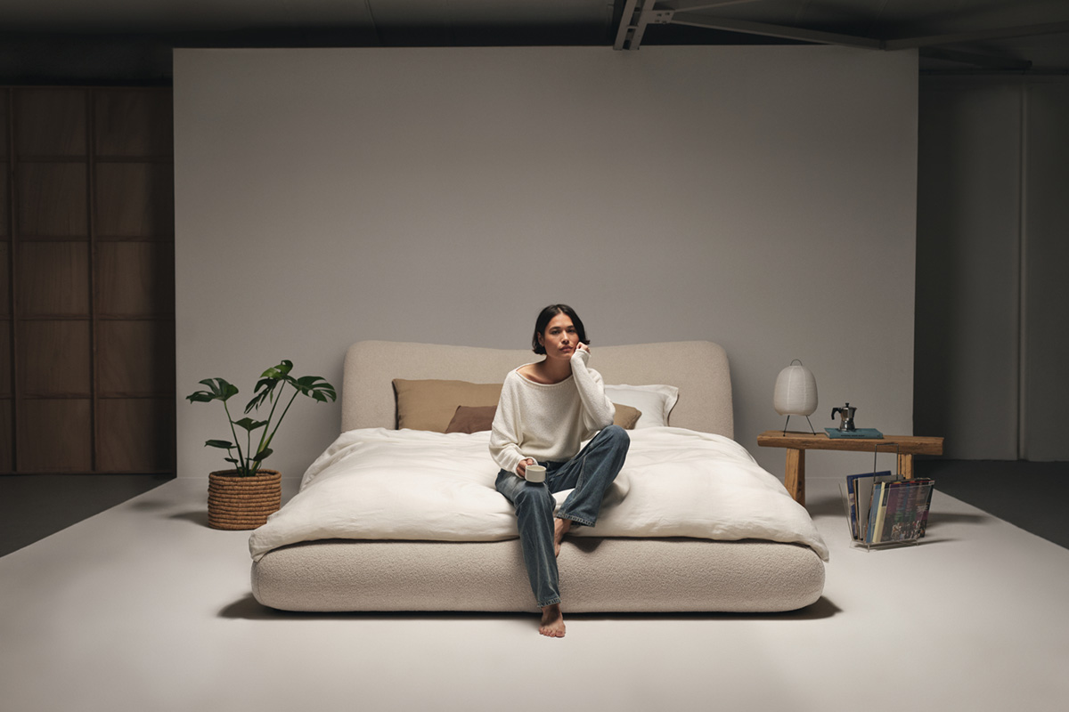 Retro-style bed in a box with removable covers in bouclé fabric. Styled in studio apartment with minimalist décor.