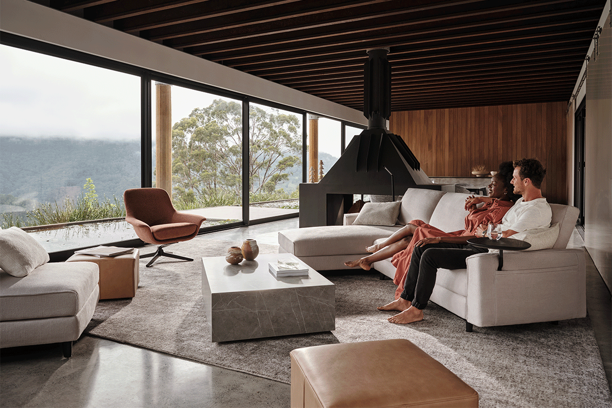 A modern living room with various pieces of contemporary furniture and a large window.