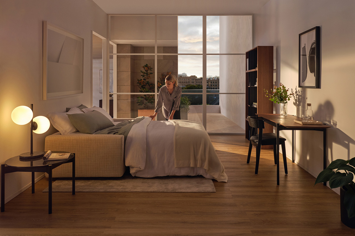 A small space studio apartment featuring a compact and comfortable sofa bed, the room is lit softly with warm ambience.