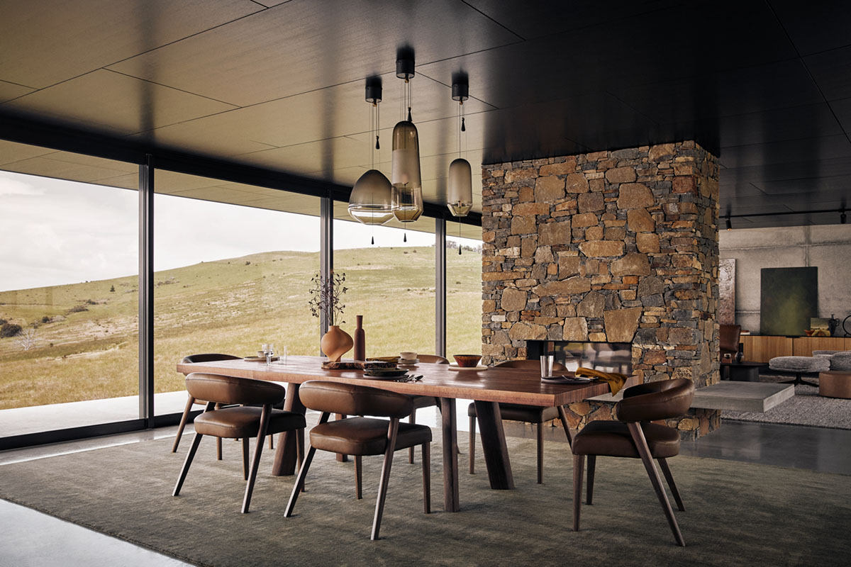 Modern dining room featuring timber table and chairs with stone wall backdrop and panoramic views.