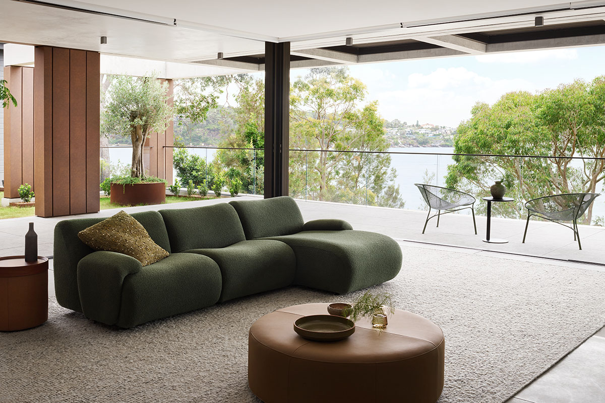 Green sofa in a contemporary living room with a natural outlook through the windows